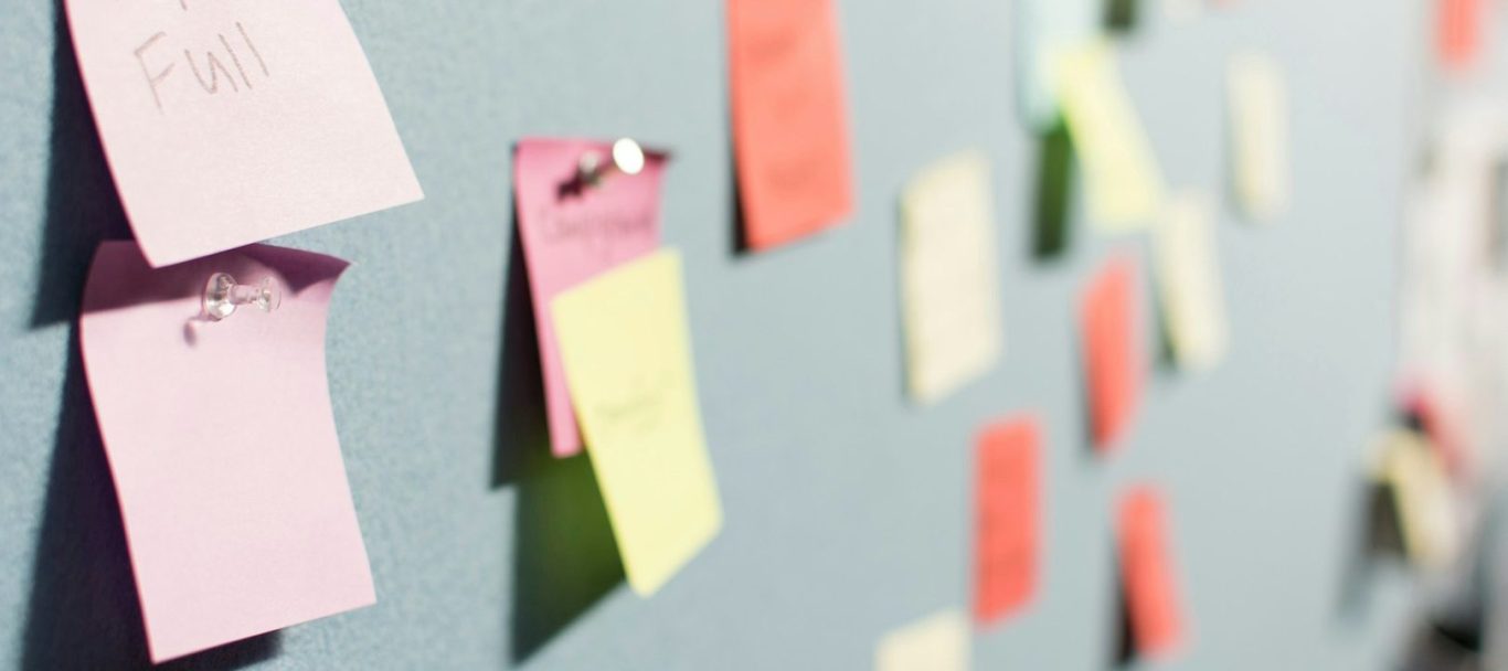 Bunte Haftnotizen auf einer Wand in unscharfer Perspektive für ein gutes Brand Naming.