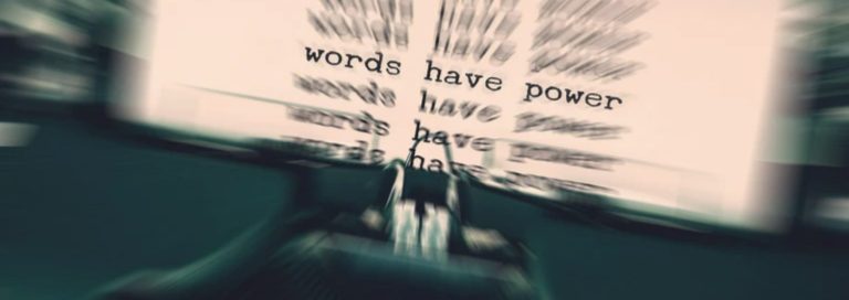 schreibmaschine Bewegte Typenmaschine mit dem Text "Worte haben Macht" im Hintergrund bei einer Namensagentur.