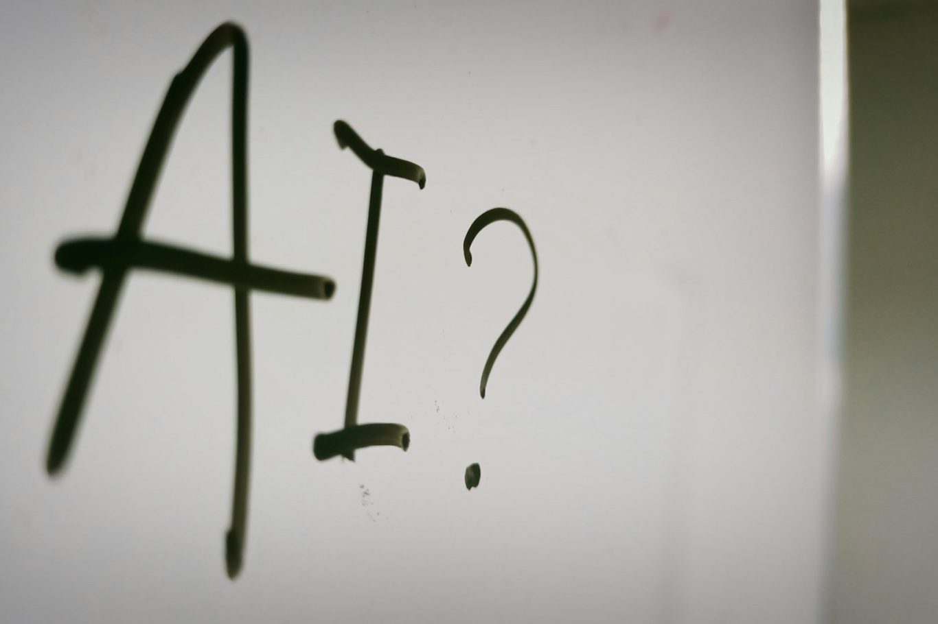 Schwarze Schrift auf hellem Hintergrund mit der Aufschrift "AI?"